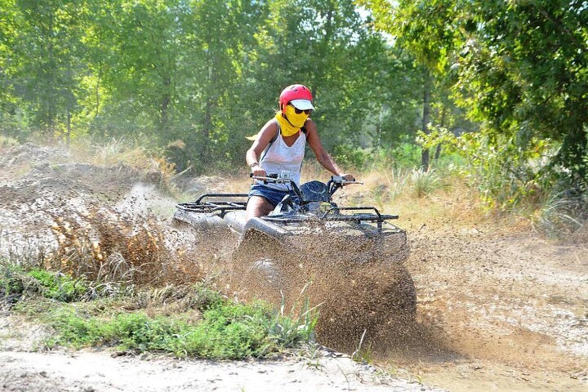una persona che guida un quad lungo una strada sterrata