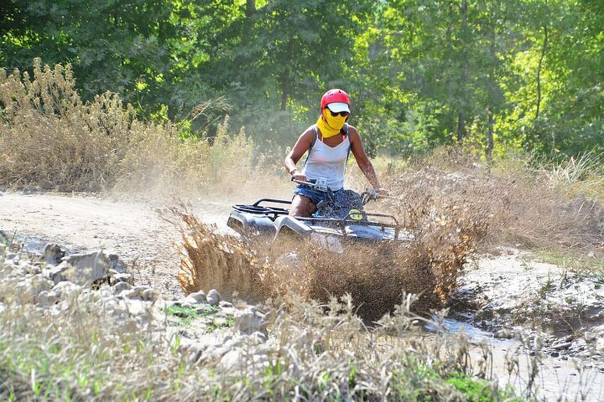 una persona che guida un quad attraverso un campo