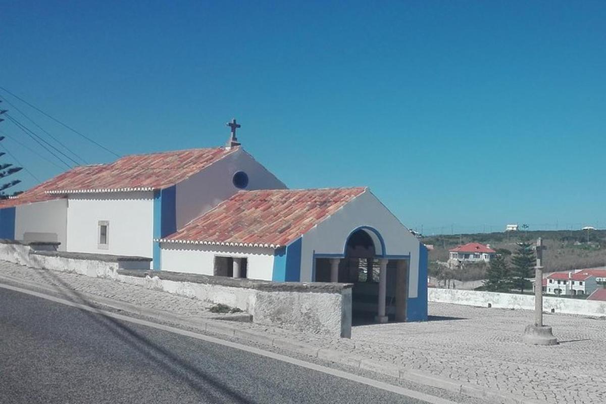 a small blue and white church with a red roof