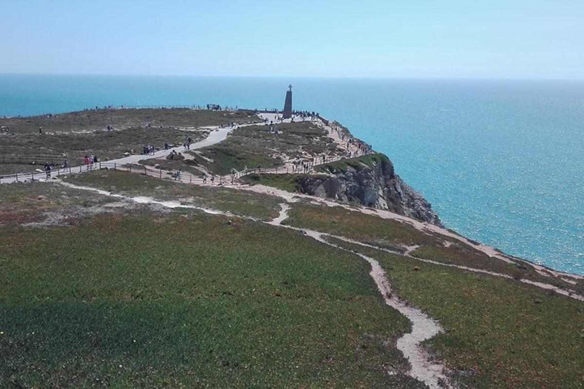 a path leading to a lighthouse on a cliff near the ocean