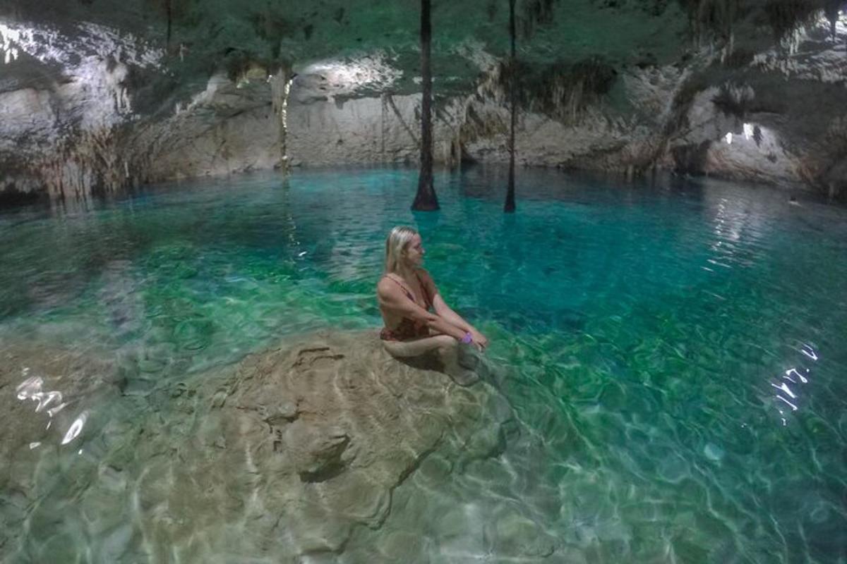 a woman sitting on a rock in a pool of water