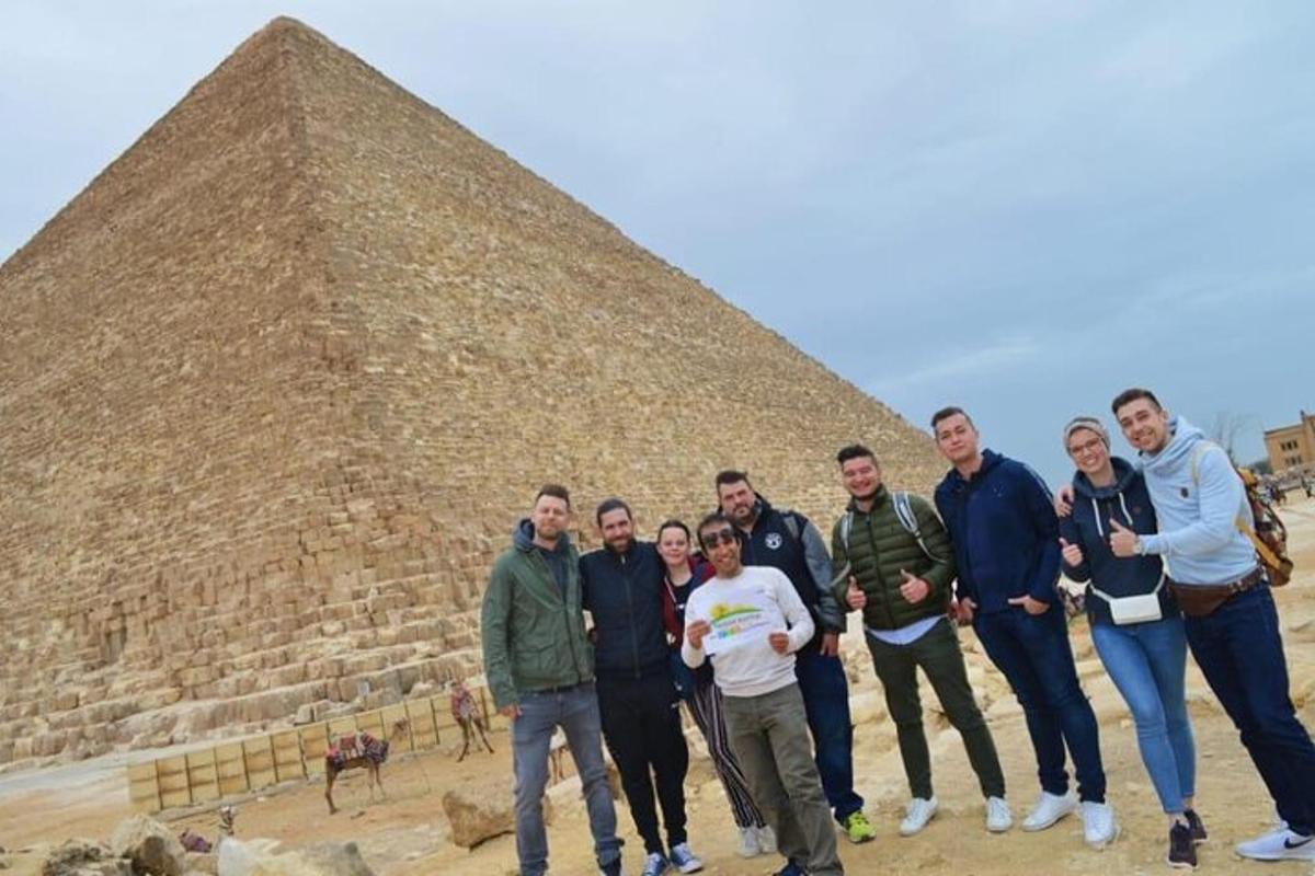 un gruppo di persone in piedi davanti a una piramide