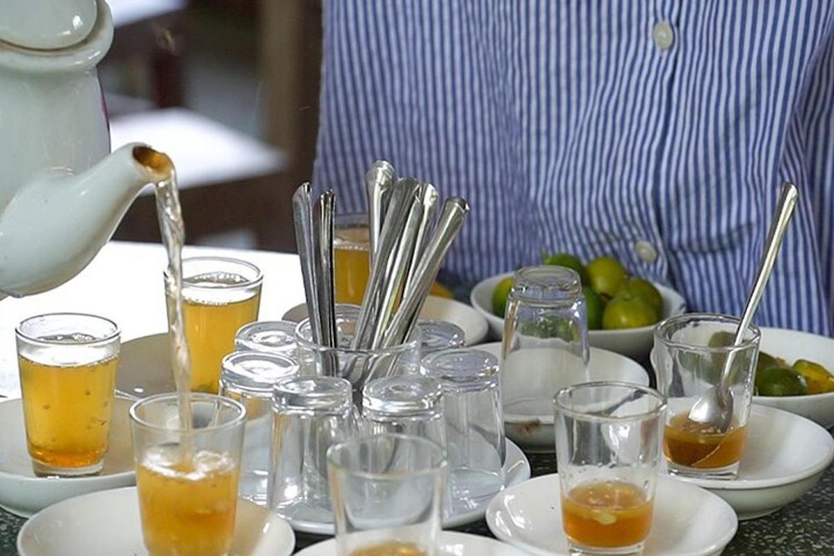 a table with glasses of drinks and a kettle