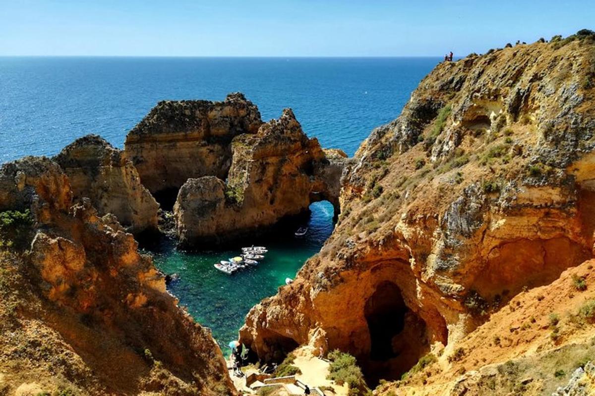 كهف في جانب الجبل مع قوارب في الماء