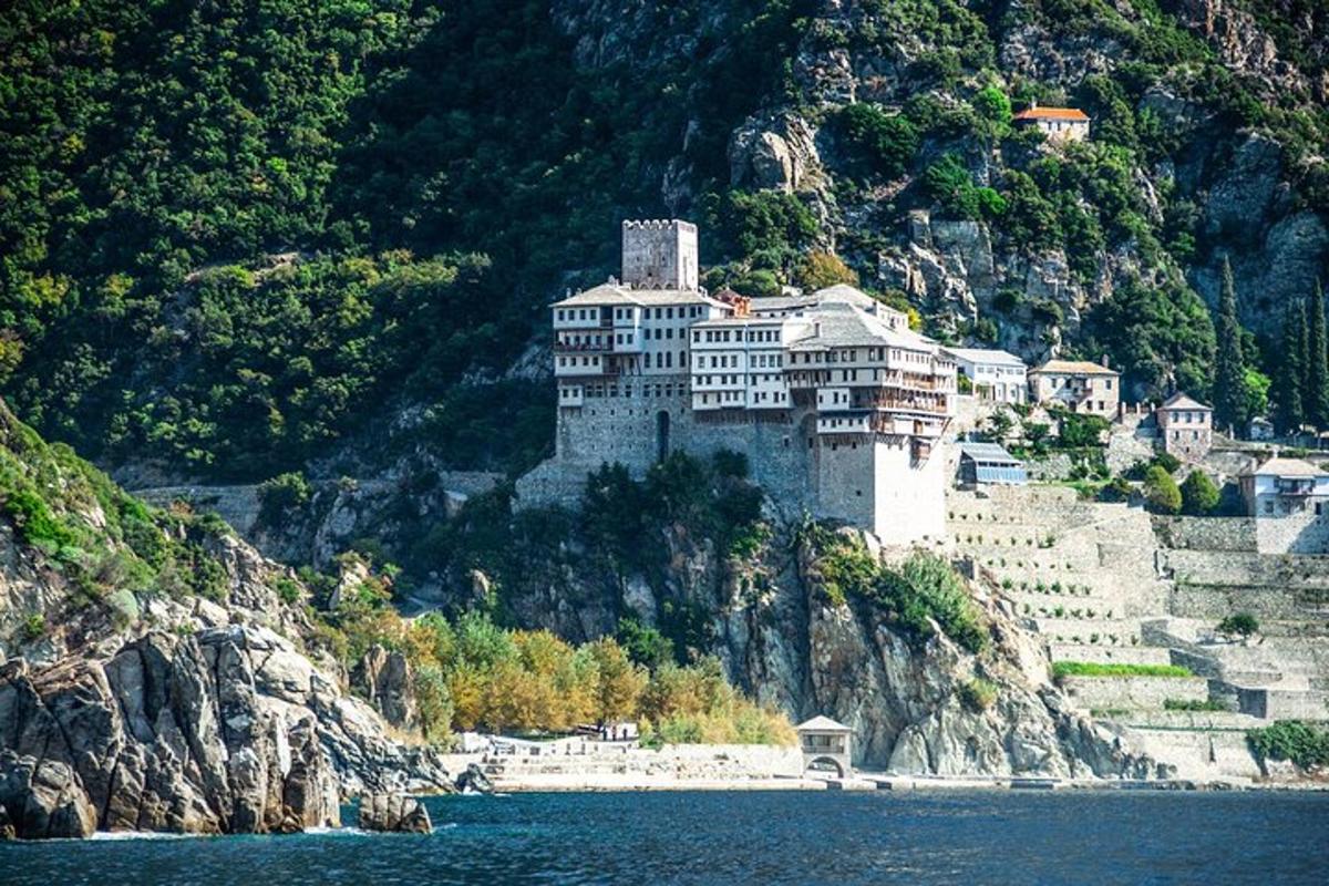 a large building on a mountain next to the water