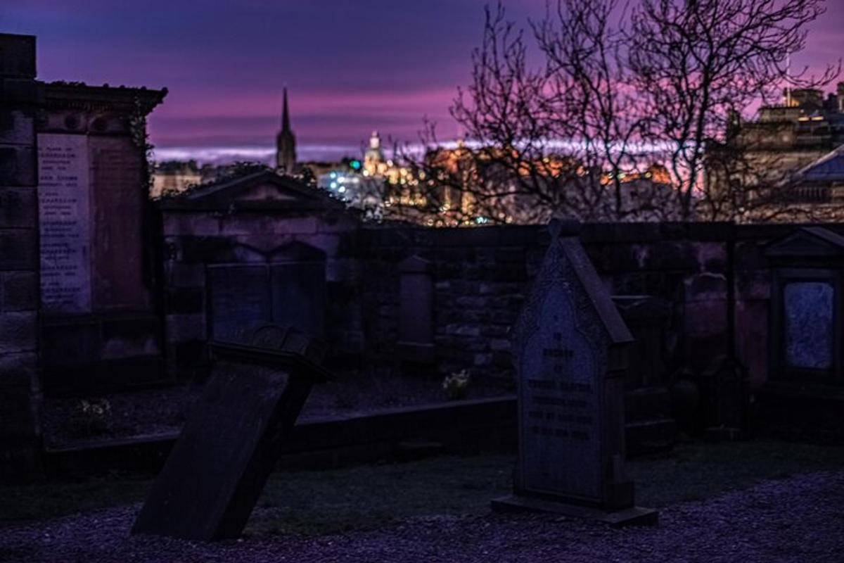 a cemetery at night with a city in the background