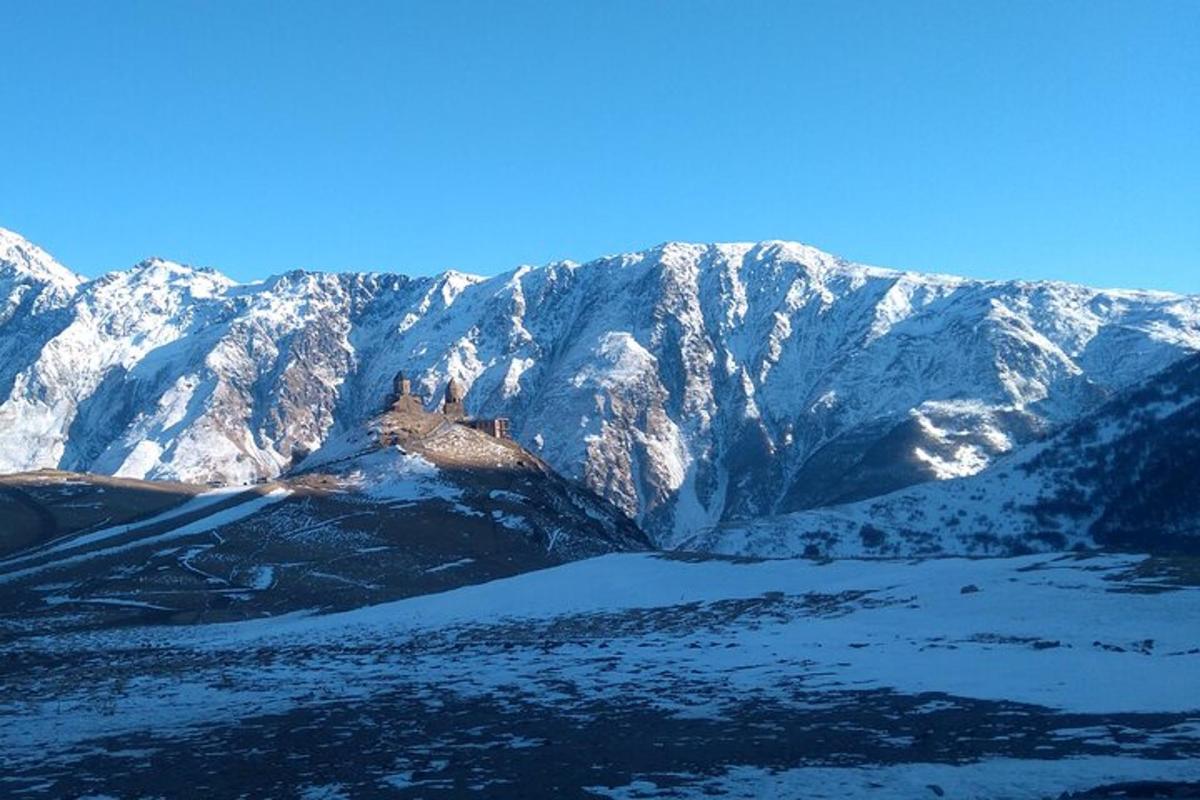 una montagna coperta di neve con un lago di fronte