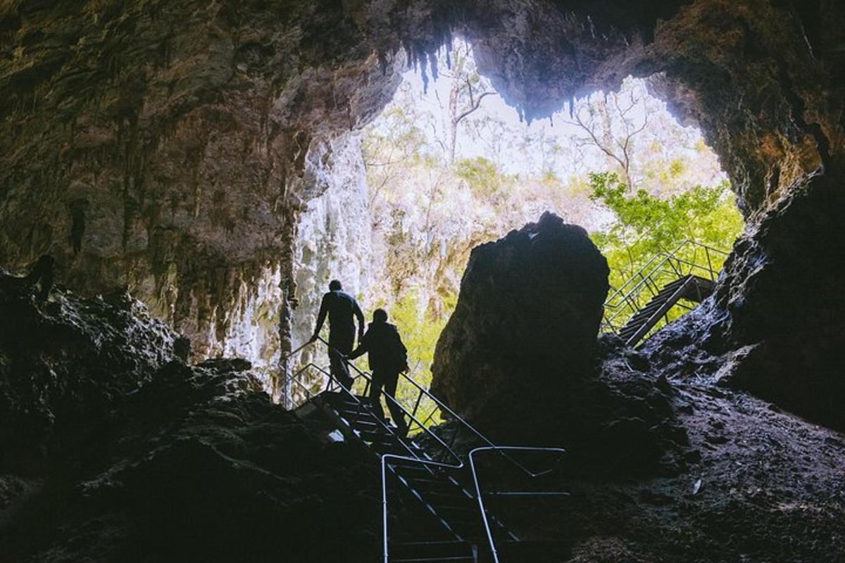 two people walking up stairs in a cave