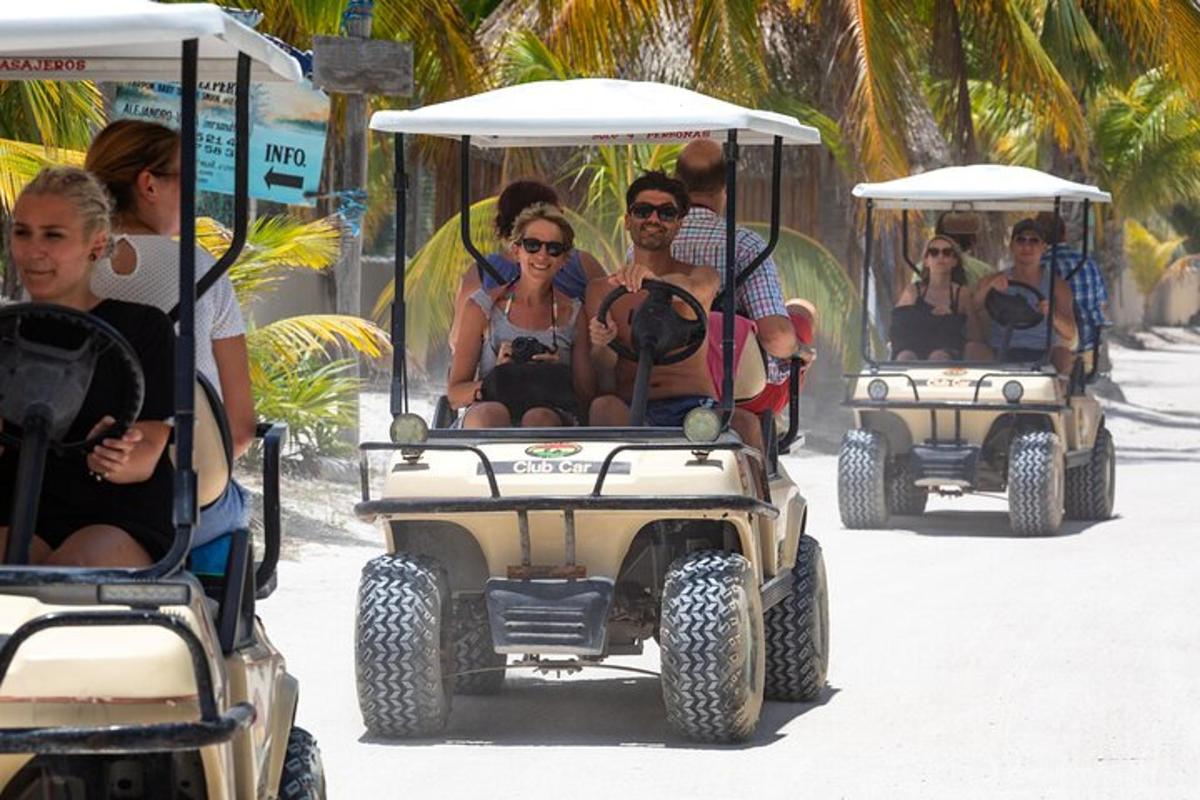 sekumpulan orang menaiki kereta golf di pantai