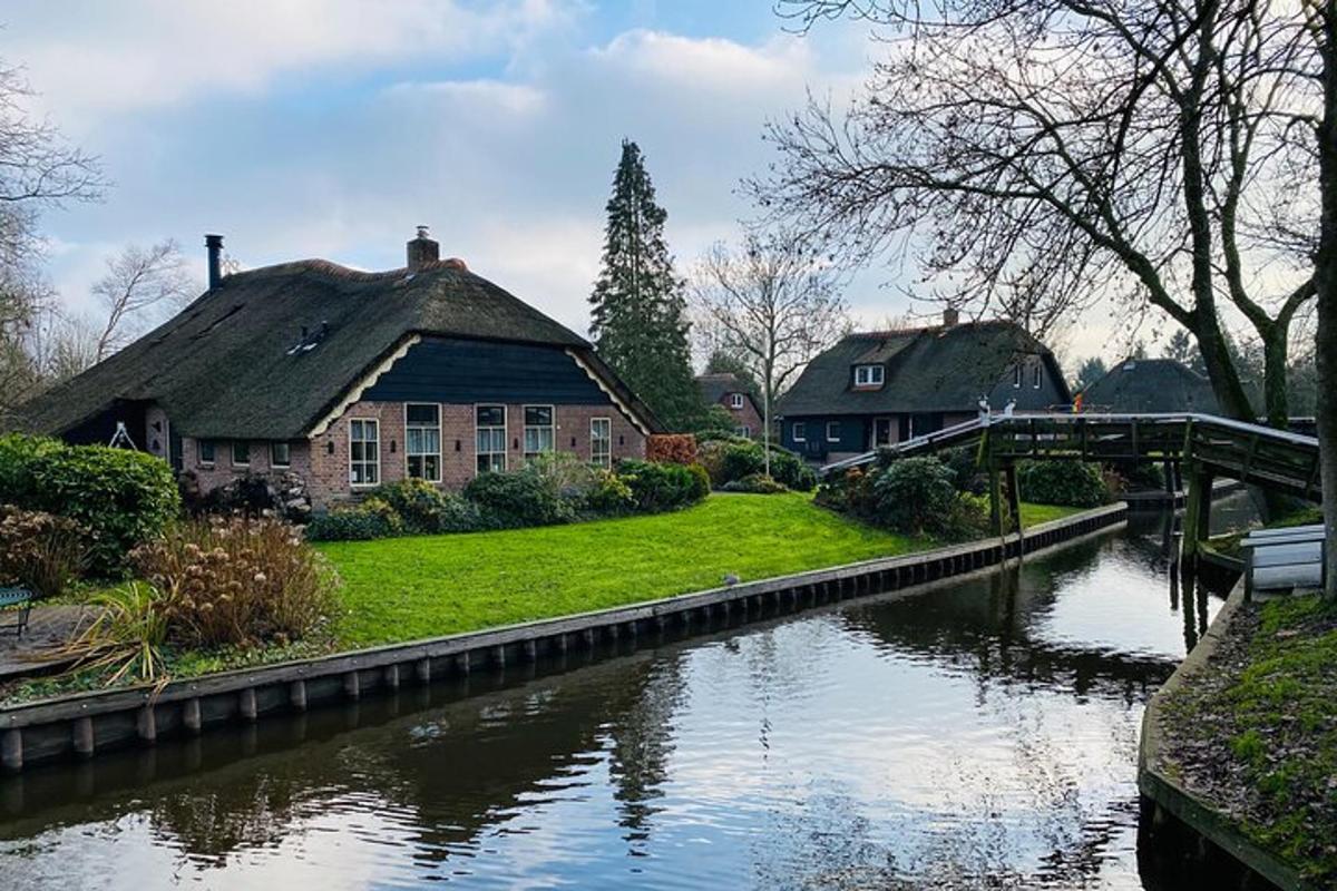 a house next to a river with a bridge