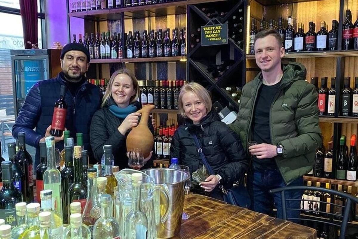 Un grupo de personas de pie alrededor de una mesa con botellas de vino.
