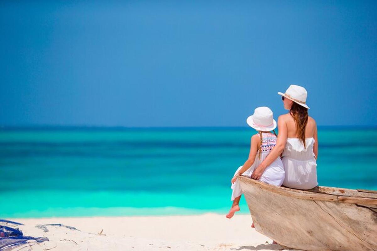 una donna e un bambino seduti su una barca sulla spiaggia