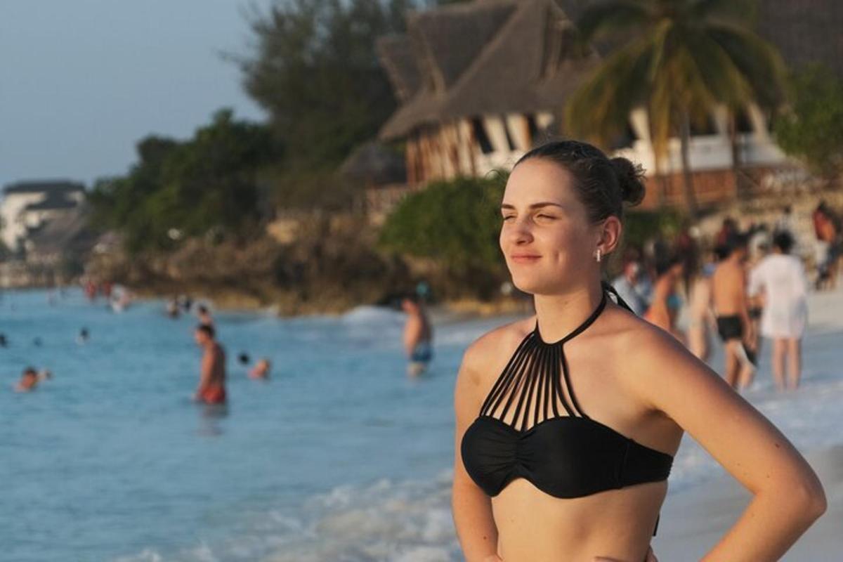 una donna in bikini in piedi sulla spiaggia