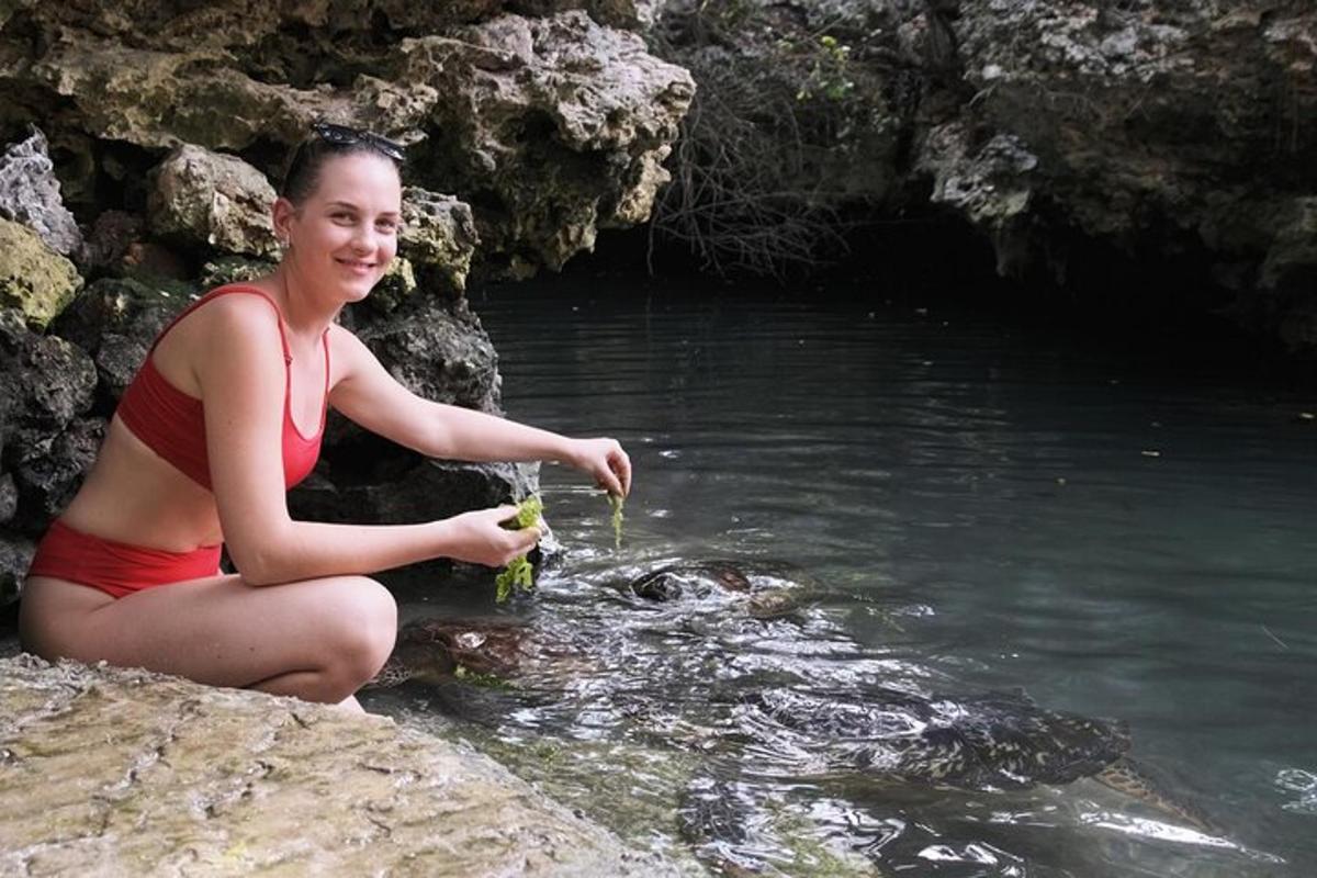 una donna seduta su una roccia nell'acqua