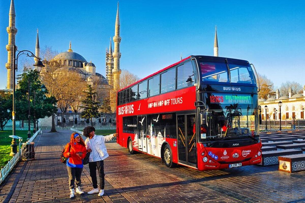 červený dvoupatrový autobus před mešitou