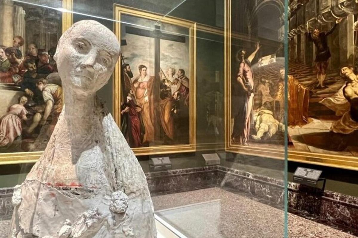 a statue in a museum with paintings on the wall