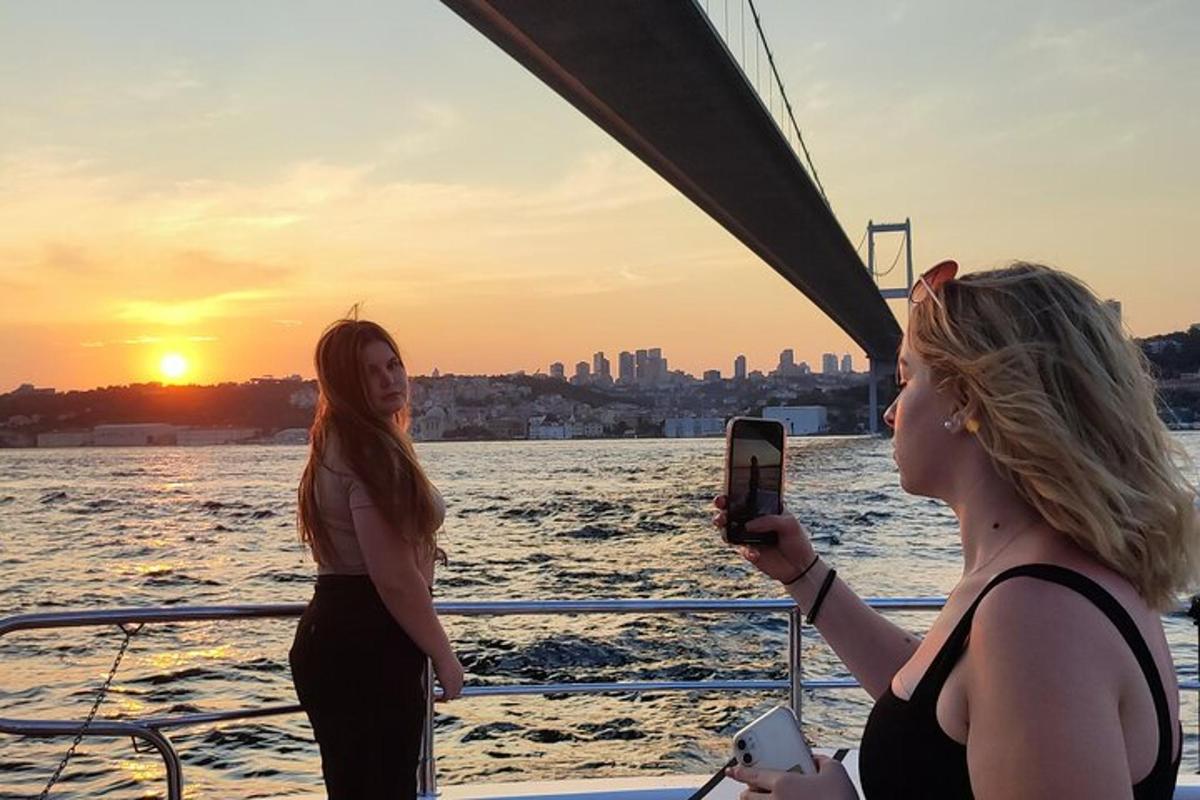duas mulheres em um barco tirando uma foto do pôr do sol