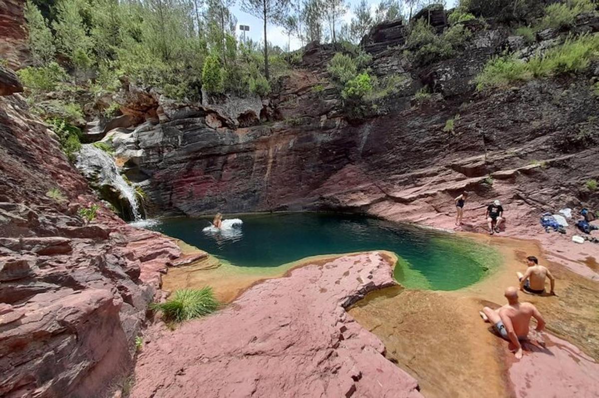 un grup de persones en un bassal d'aigua en un canyó