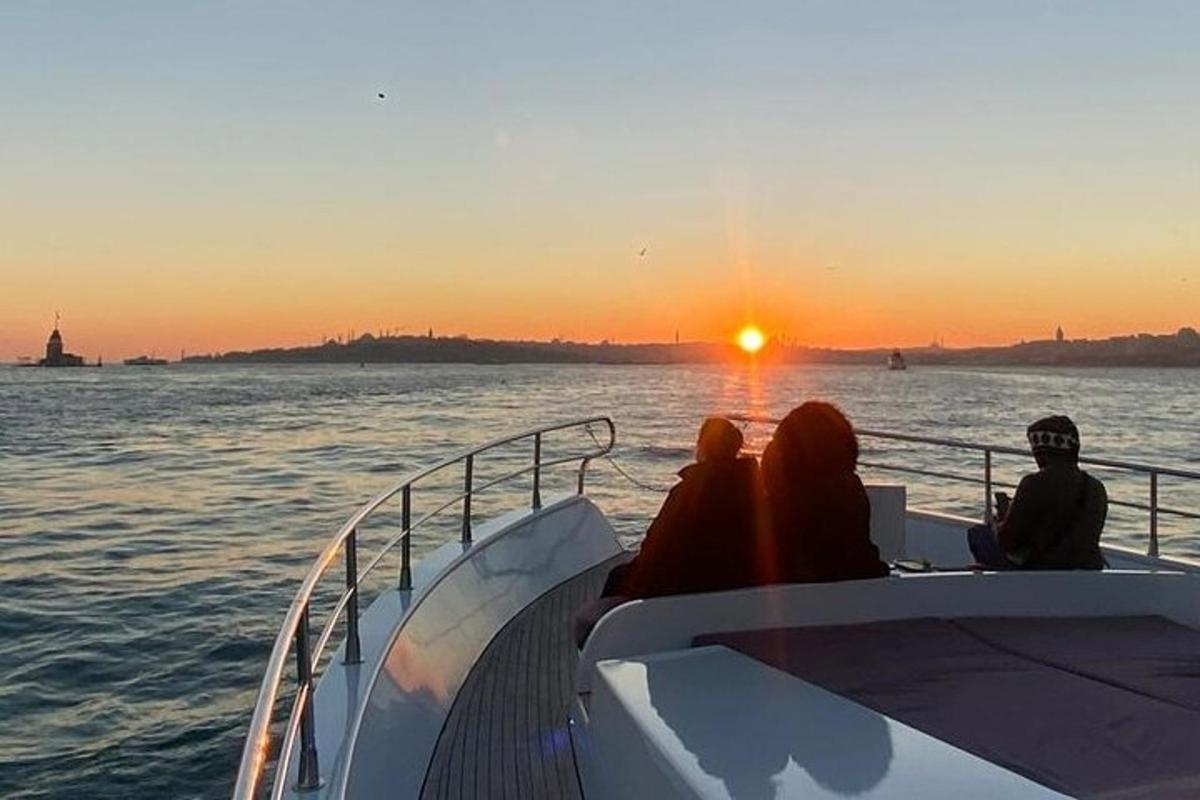 um grupo de pessoas sentadas em um barco assistindo ao pôr do sol