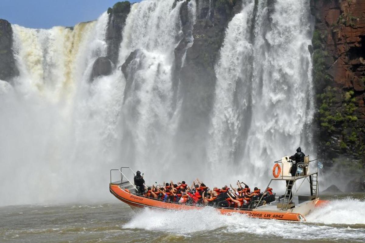 eine Gruppe von Menschen auf einem Boot vor einem Wasserfall