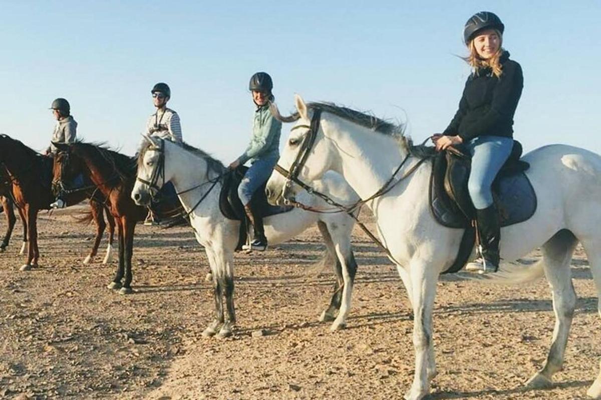 a group of people riding horses on a field