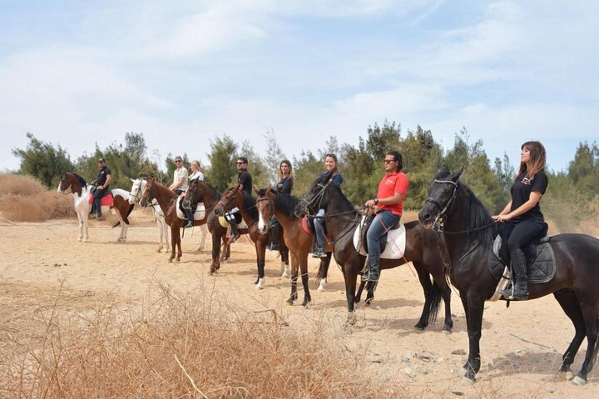 a group of people riding horses on a dirt road