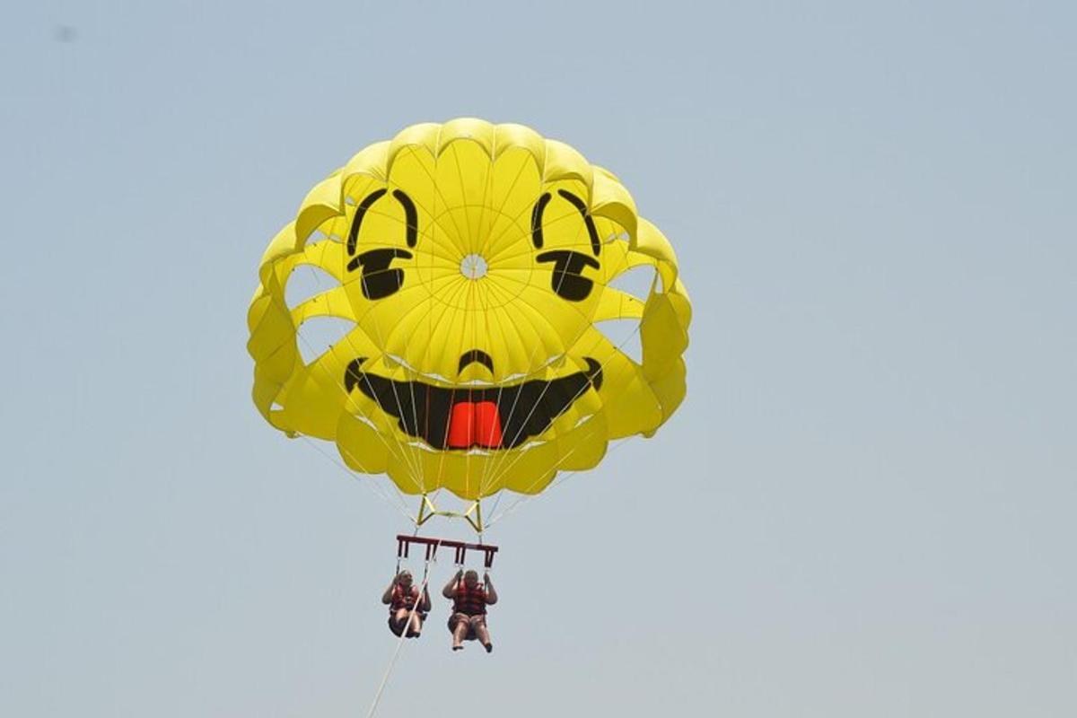 a yellow smiley face kite flying in the sky