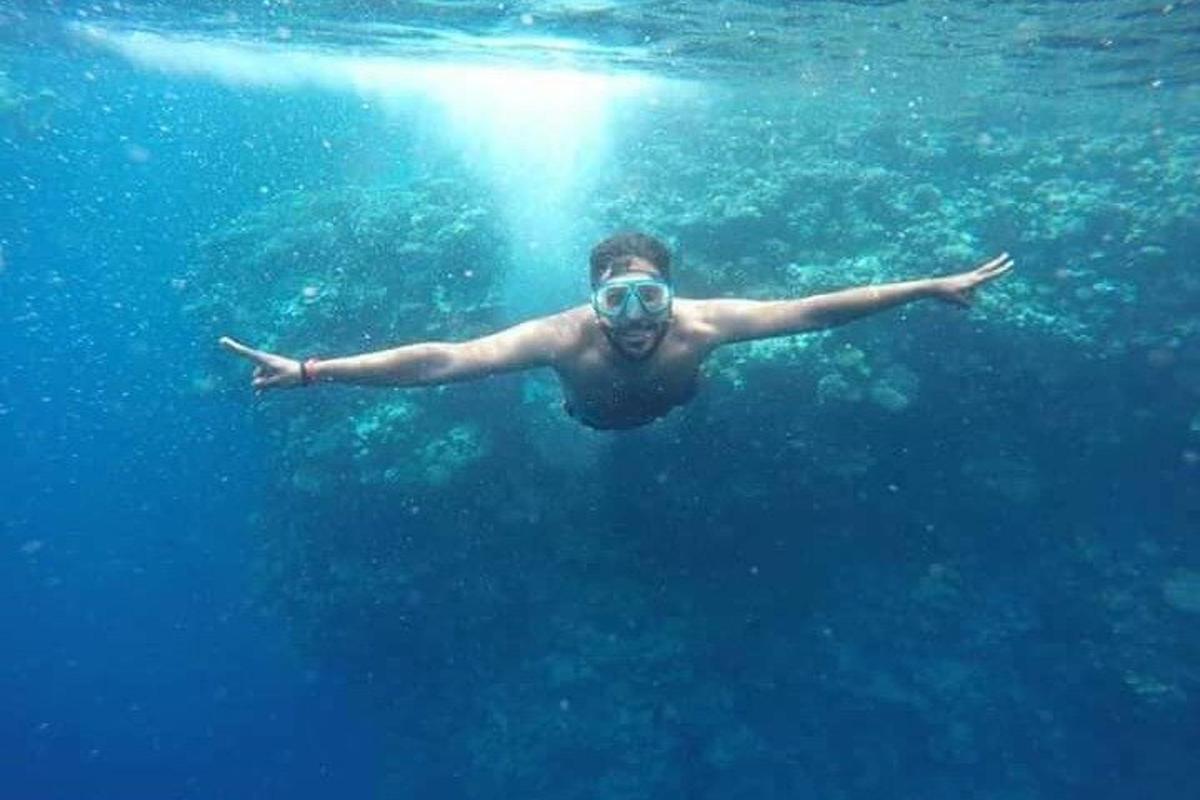 un uomo con una maschera che nuota nell'acqua