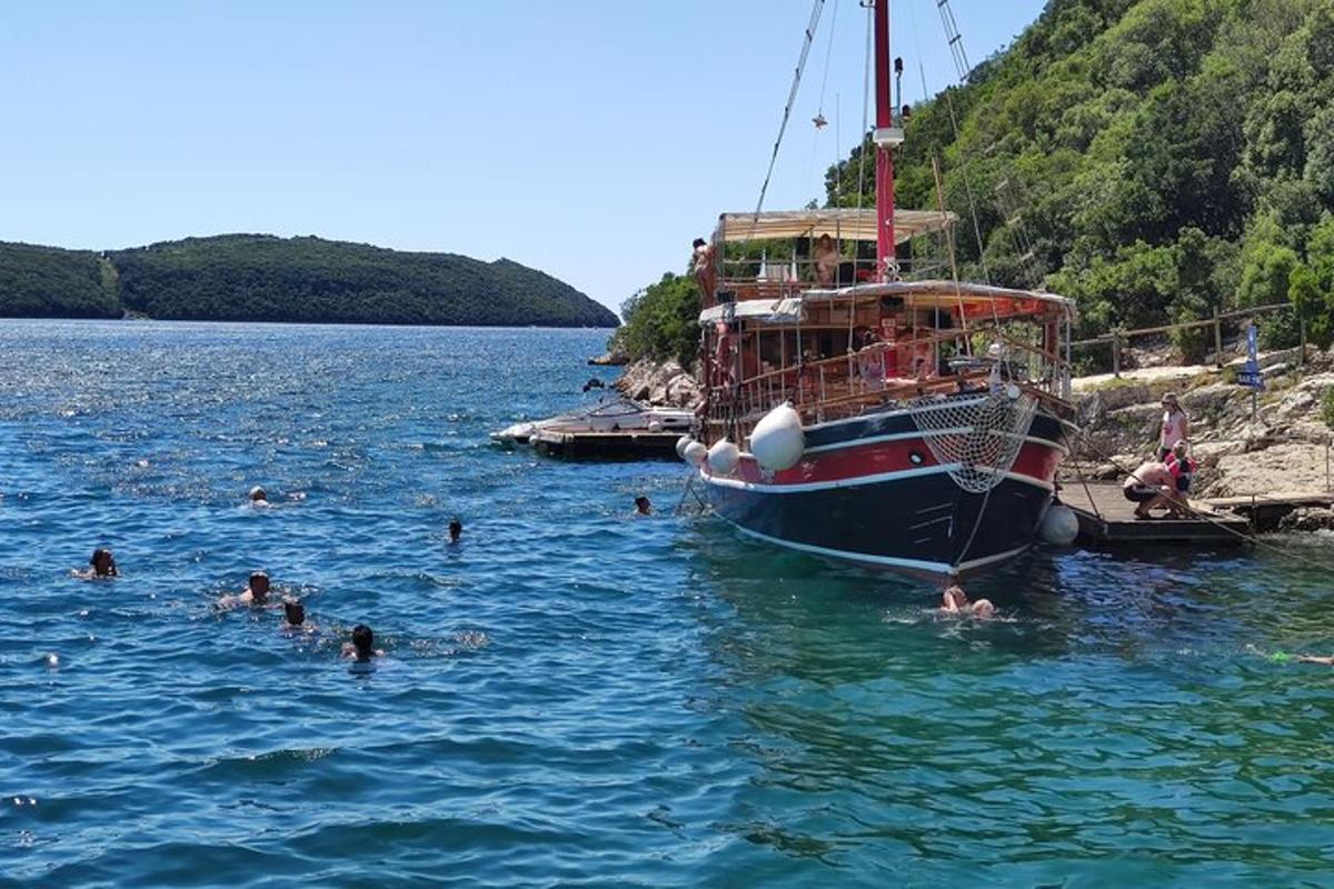 a group of people swimming in the water next to a boat