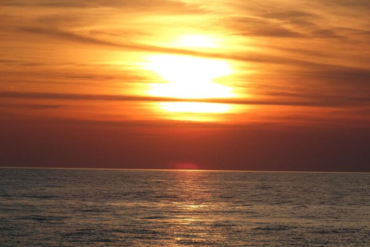 západ slunce nad oceánem se sluncem na obloze