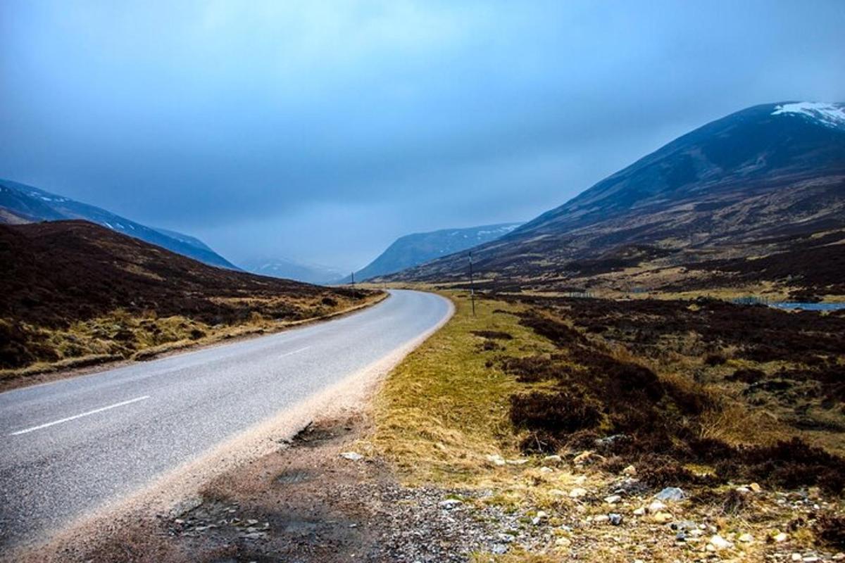 an empty road in the middle of a mountain