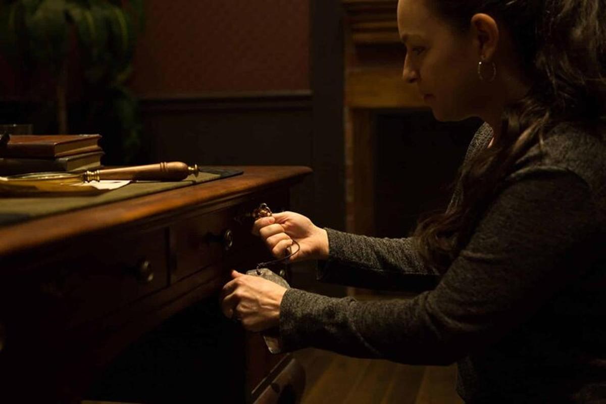 una donna in piedi davanti a una scrivania con le mani