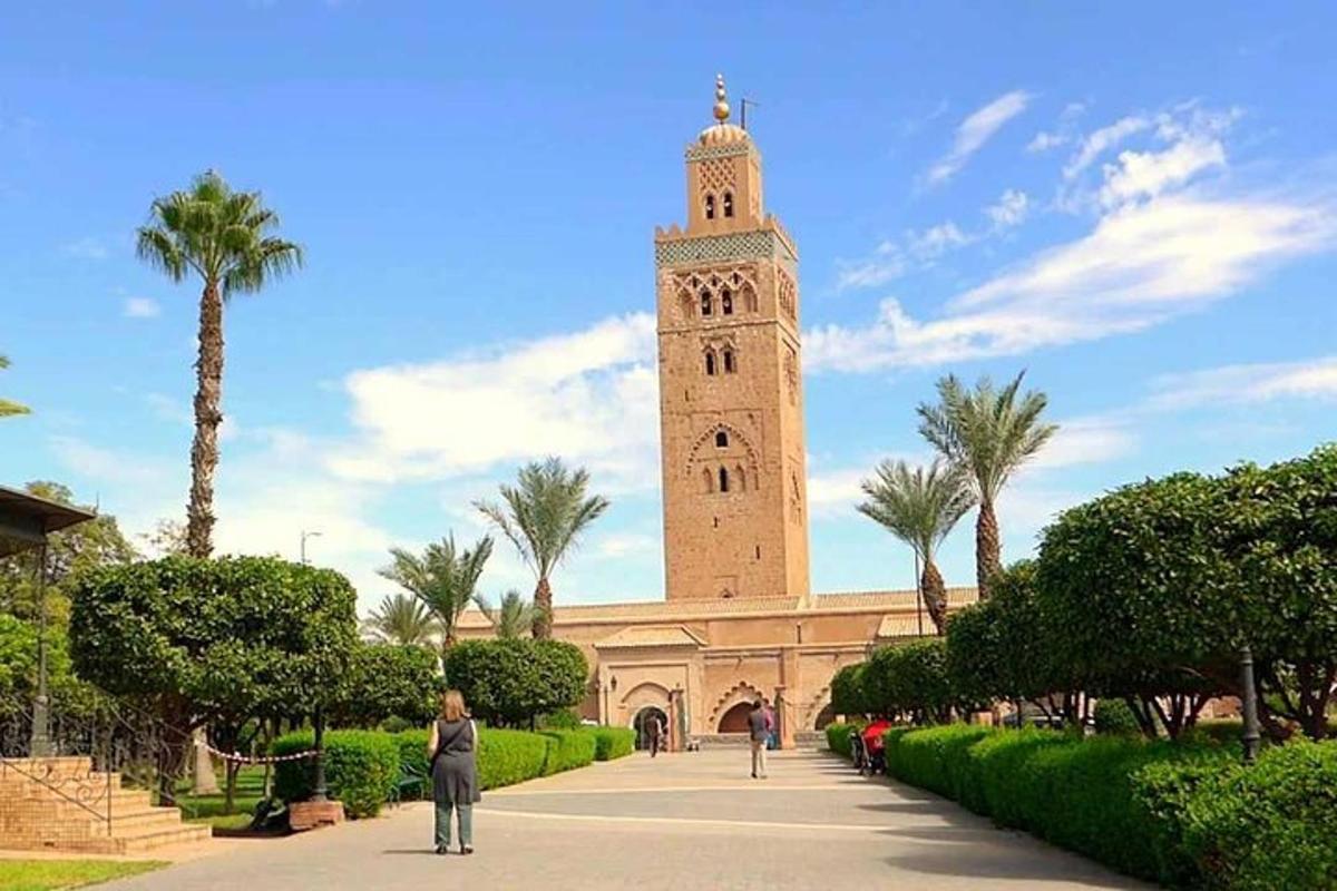 a large building with a clock tower with palm trees