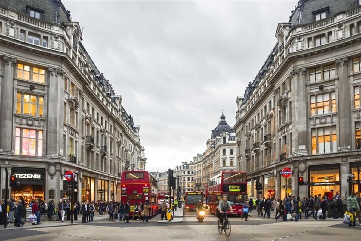 a busy city street with double decker buses and people