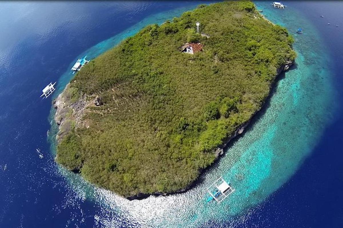 sebuah pulau di lautan dengan bot di dalam air