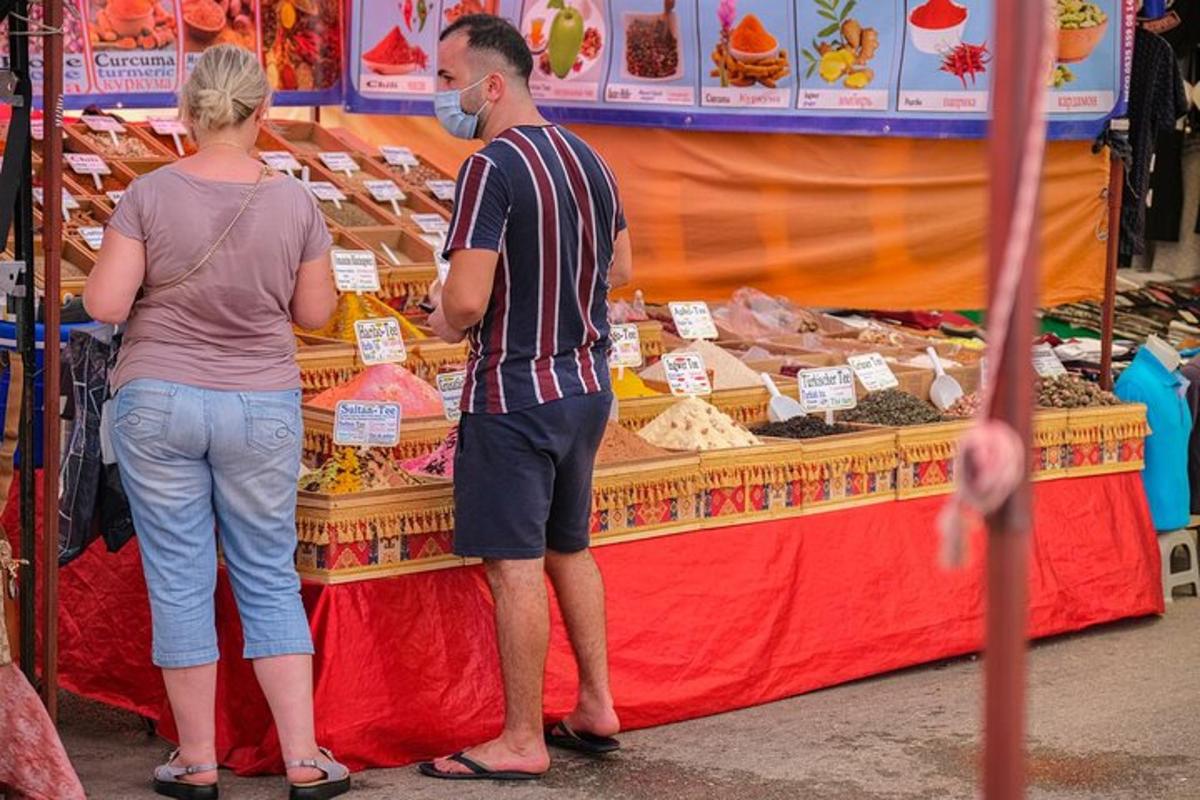 un uomo e una donna in piedi davanti a una bancarella di cibo