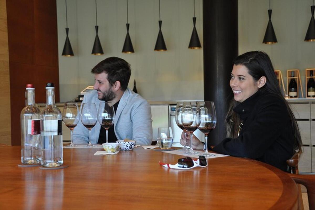 Un hombre y una mujer sentados en una mesa con copas de vino.