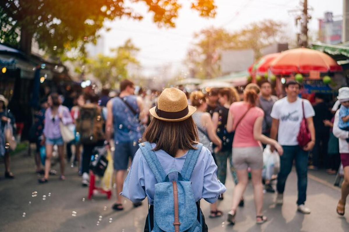 a crowd of people walking down a busy street