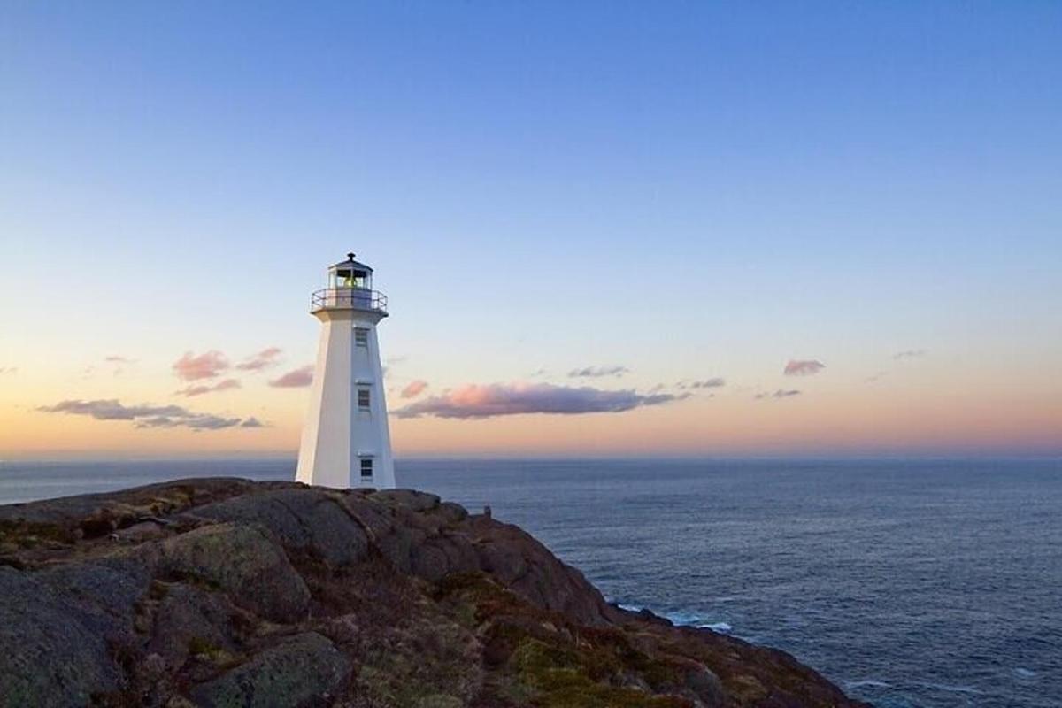 a lighthouse sitting on top of a cliff near the ocean