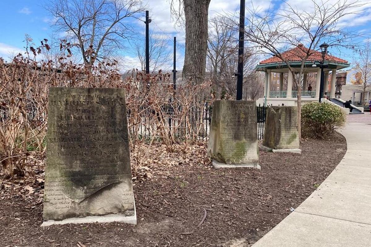 a group of stone posts in a park with a gazebo