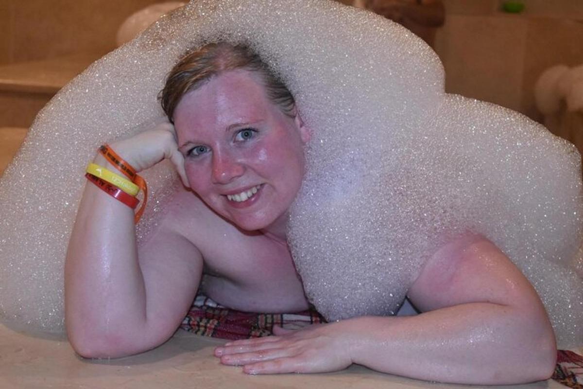 seorang wanita berbaring di dalam tab mandi yang dilitupi buih