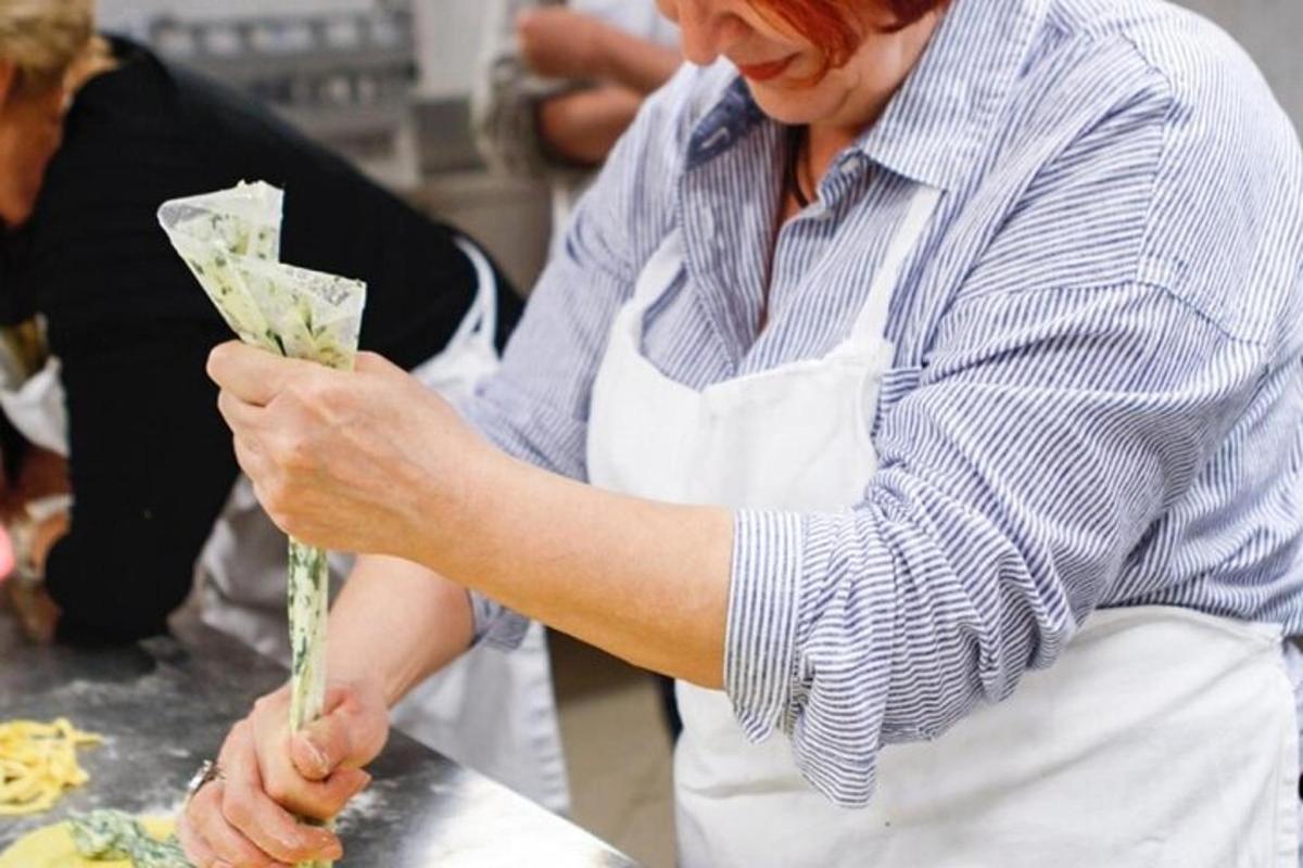 una donna in cucina che tiene in mano un pezzo di cibo