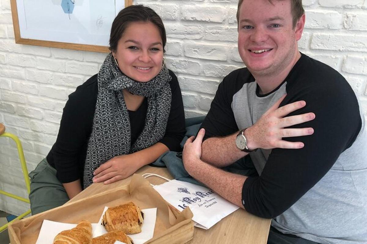 Un hombre y una mujer sentados en una mesa con un plato de pan.