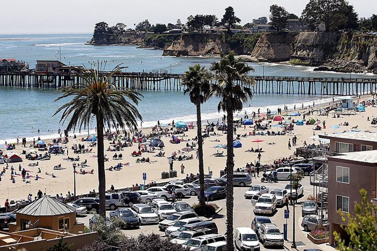 a beach with a lot of people and a pier