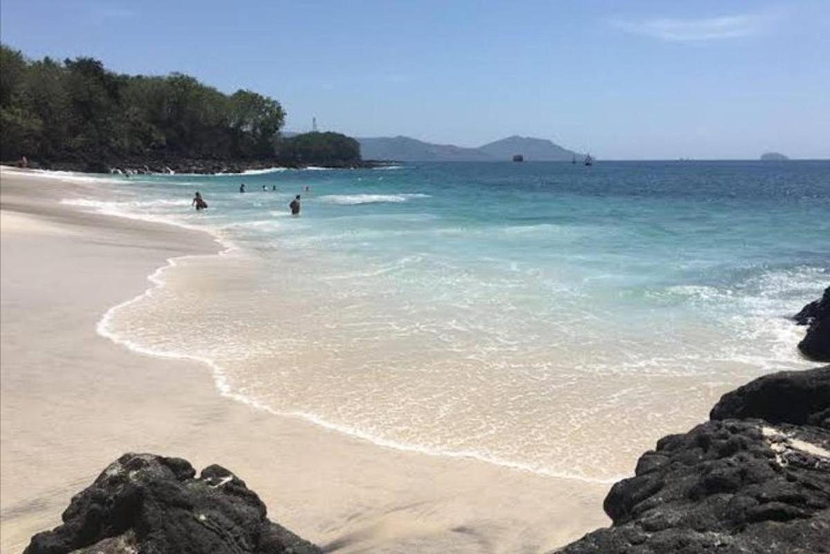 a beach with people swimming in the water
