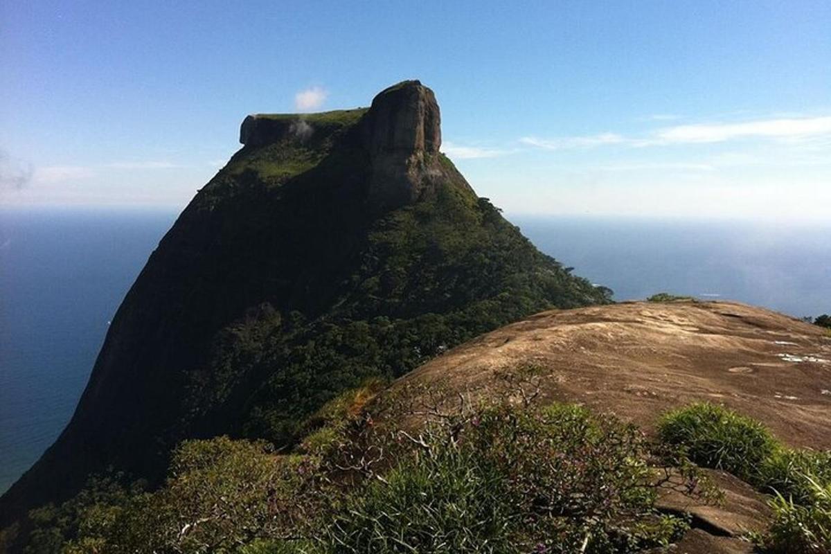 a large mountain with the ocean in the background