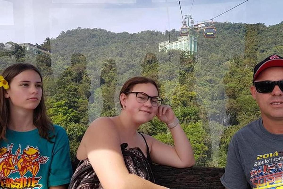tiga orang duduk di bangku di depan gunung