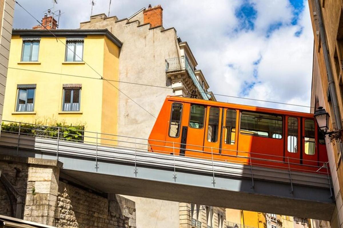 oranžový vlak na mostě nad městem