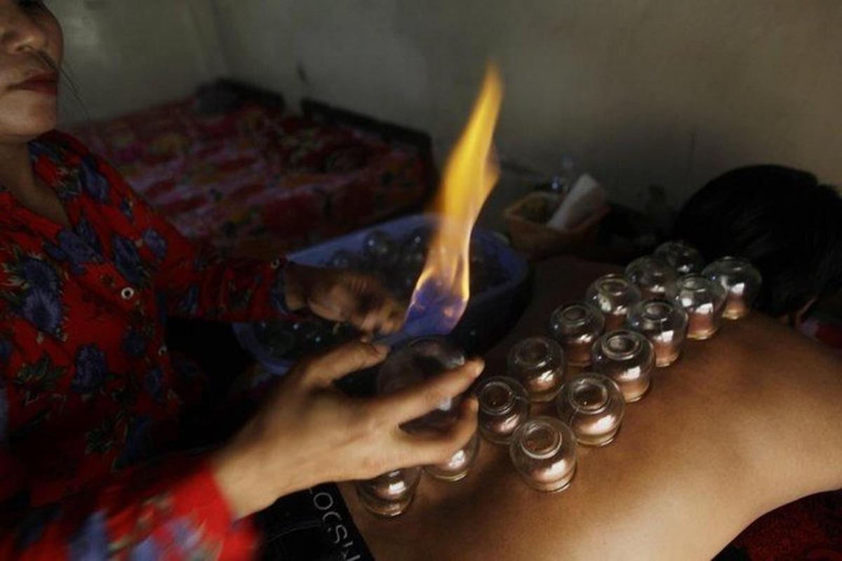 a woman is holding a fire in front of cupcakes