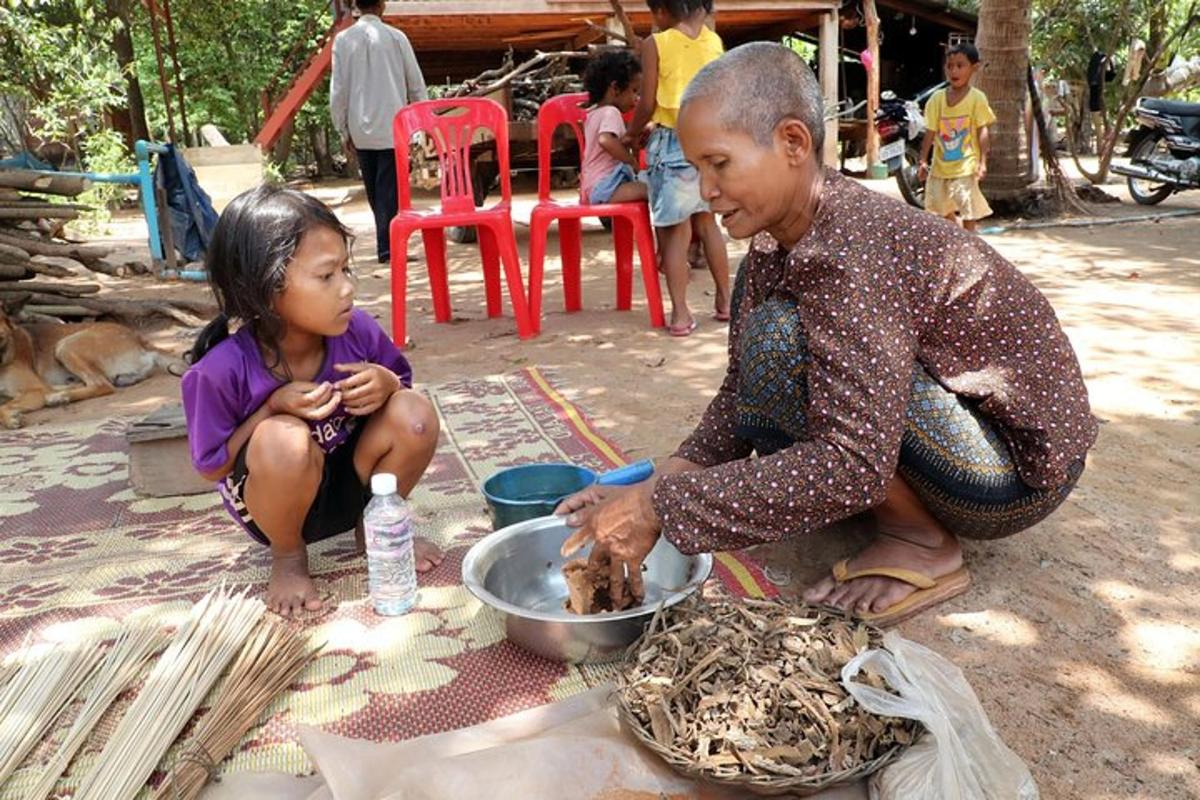 seorang lelaki dan seorang gadis kecil duduk di sebelah mangkuk makanan